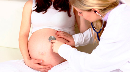 врач осматривает беременную женщину